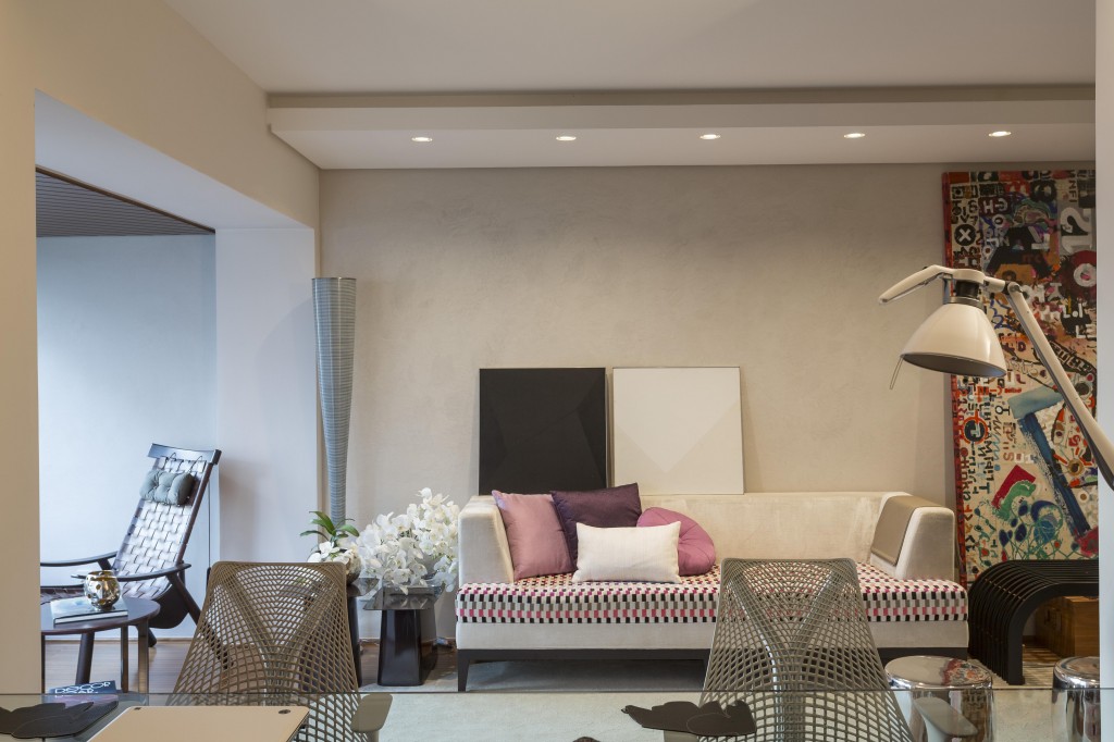 Iluminado e com pinceladas de cor na medida certa, o estar revestido com estuque veneziano agora se integra ao terraço. O veludo estampado de pixels da Shaco incrementou o mobiliário combina-se às almofadas. Repare em primeiro plano, a bancada de trabalho em vidro, que faz divisória com o home theater.