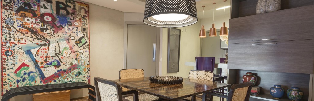Com a reforma, a cozinha e o living relacionam-se por meio de um balcão. Composto por mesa para quatro pessoas, o jantar ganhou cadeiras em palhinha e pendente da Bertolucci e é servido pela estante que o separa da área de serviço. O piso de perobinha (Indusparquet) unifica os espaços.