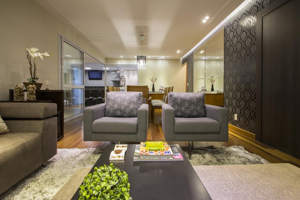 No living, as poltronas de chenille e o tapete de náilon não apenas propiciam conforto como também delimitam o canto de estar, que recebeu uma mesa de centro em laca preta.