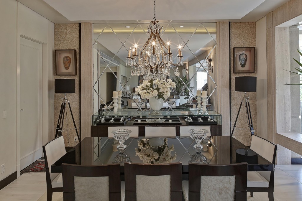 Formada pelo conjunto de mesa e cadeiras da Brentwood, a sala de jantar ganhou sofisticação graças a detalhes como o espelho recortado em forma de losangos com acabamento bisotê e o lustre veneziano de cristal.