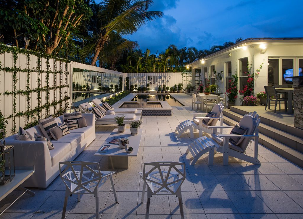 O exterior da casa foi transformado em um espaço completo de lazer, com piscina e área de estar, oferecendo várias opções para receber os convidados. O piso poroso, fosco e antiderrapante de Limestone dá um toque rústico. O destaque fica para o espelho que amplia ainda mais o ambiente e para as cadeiras One, de Konstantin Grcic.