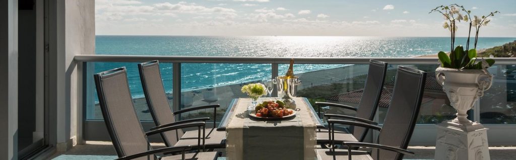 A varanda, de onde se avista Miami Beach, é ligada à cozinha gourmet e conta com mesa e cadeiras de apoio Ego Paris. O piso é revestido em mosaico de mármore bruto.