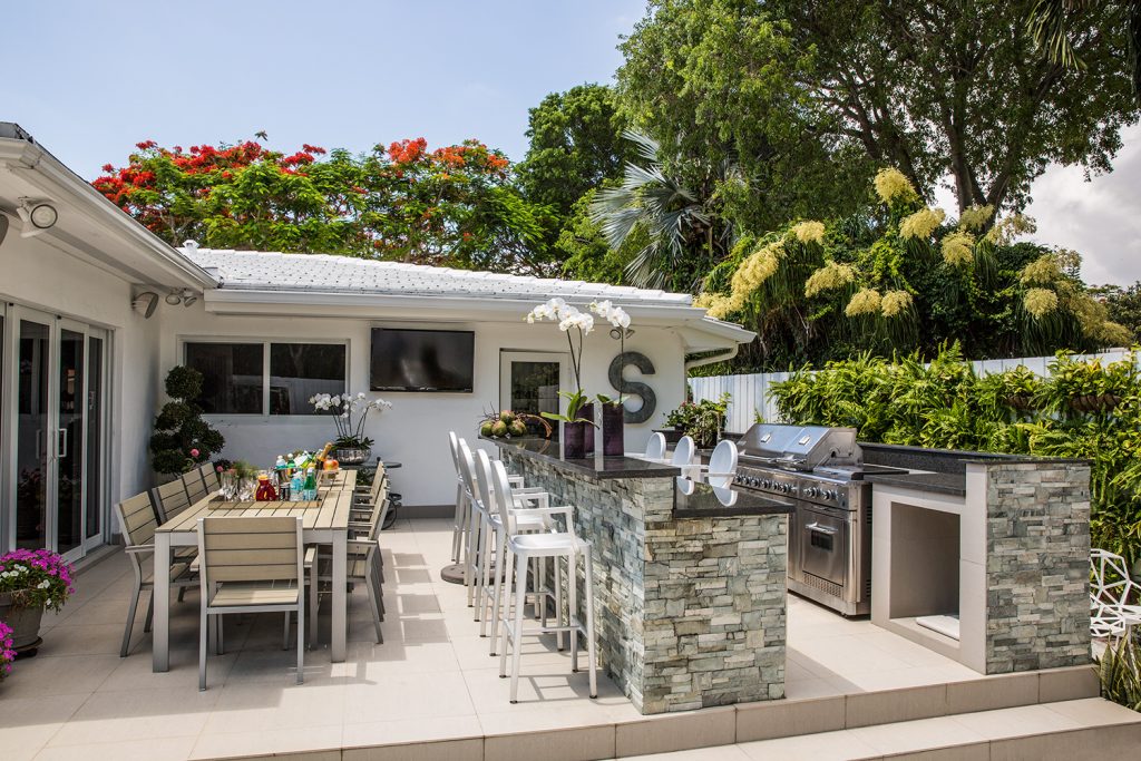A área externa conta ainda com uma estrutura completa para churrascos. Junto à ilha, as famosas banquetas da coleção Ghost, da Kartell, com design de Philippe Starck.