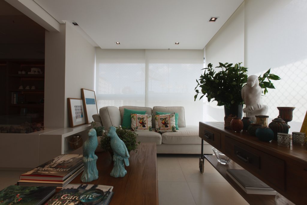 O estar integrado à varanda gourmet recebeu persianas com tela solar da Luxaflex (Alamanda Home) para filtrar a luz natural.