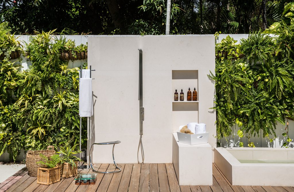 As designers não deixaram nenhum detalhe de lado para entreter e receber e se preocuparam em fazer também um espaço simples e eficaz a céu aberto para chuveiradas rápidas antes e depois do banho de piscina, com apenas chuveiro, cabide para toalhas e painel com compartimento para utensílios de higiene.