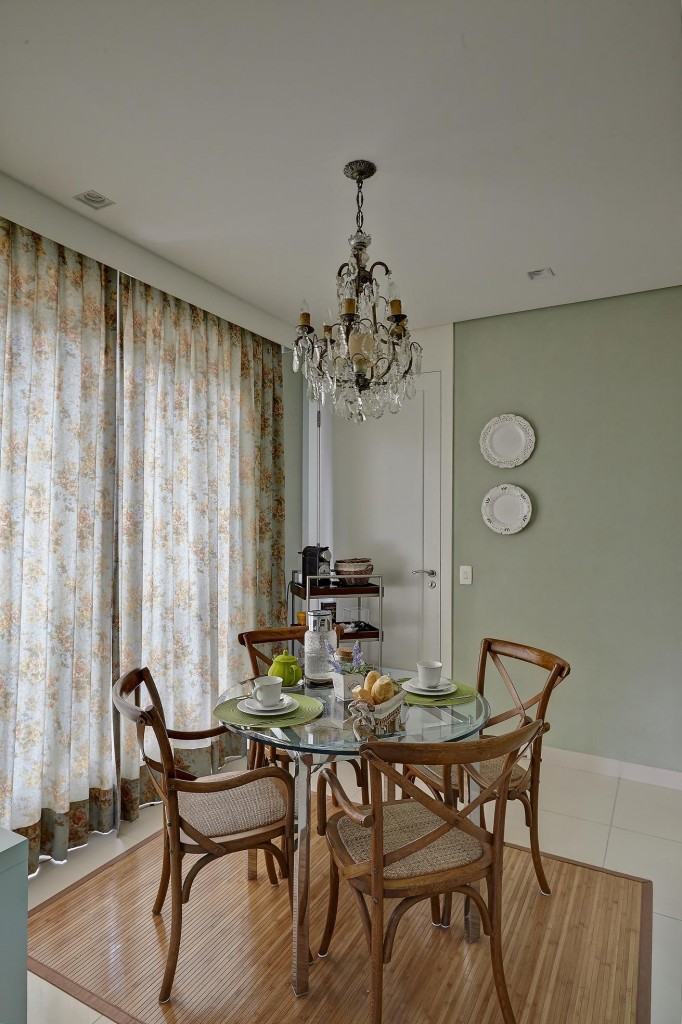 A sala de almoço em estilo provençal com móveis da Cecília Dale, cortina florida (Tecdec) e lustre veneziano, trazido da Itália pela proprietária. Na cozinha, que segue a mesma linguagem, o mobiliário da linha Charme, da Florense, compõe com o rodateto em ladrilho hidráulico.