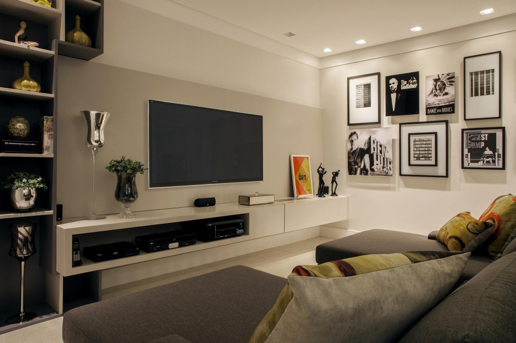 Atrás do ripado de madeira está o home theater composto por duas chaises e o painel com aparador para os equipamentos de áudio e vídeo. Foto por J. Vilharo