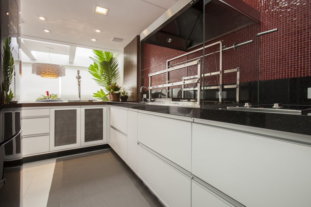 Junto à varanda, a cozzinha tem churrsqueira (Bella Telha) para os encontros com os amigos. Os armários são sob medida, executados pela Blanco Design. 